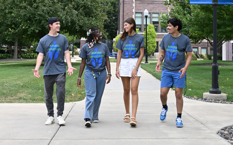 smiling AU students walk around campus in the summer
