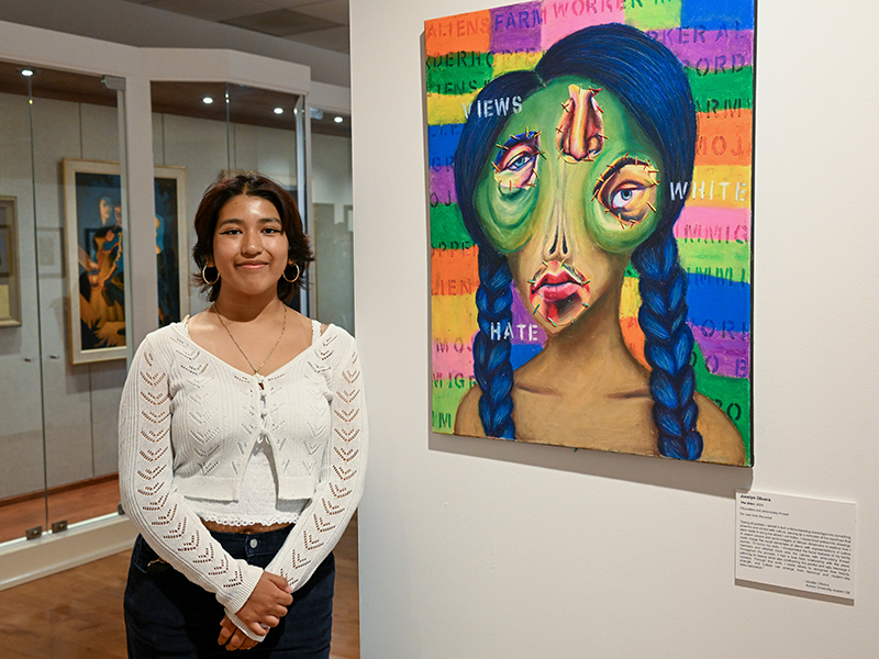 Student artist Jocelyn Olivera ’28 next to her work, "Alien"
